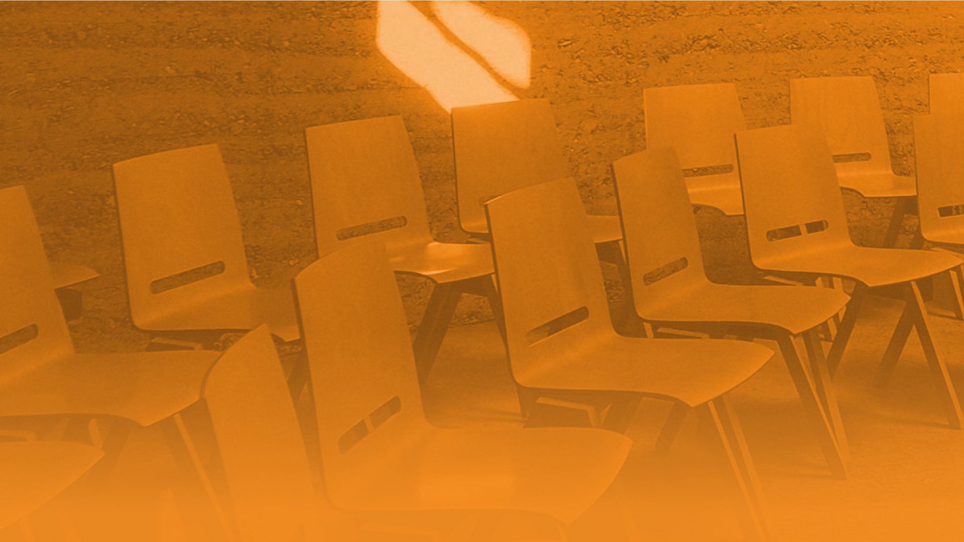 Abstract image of two rows of chairs outside.