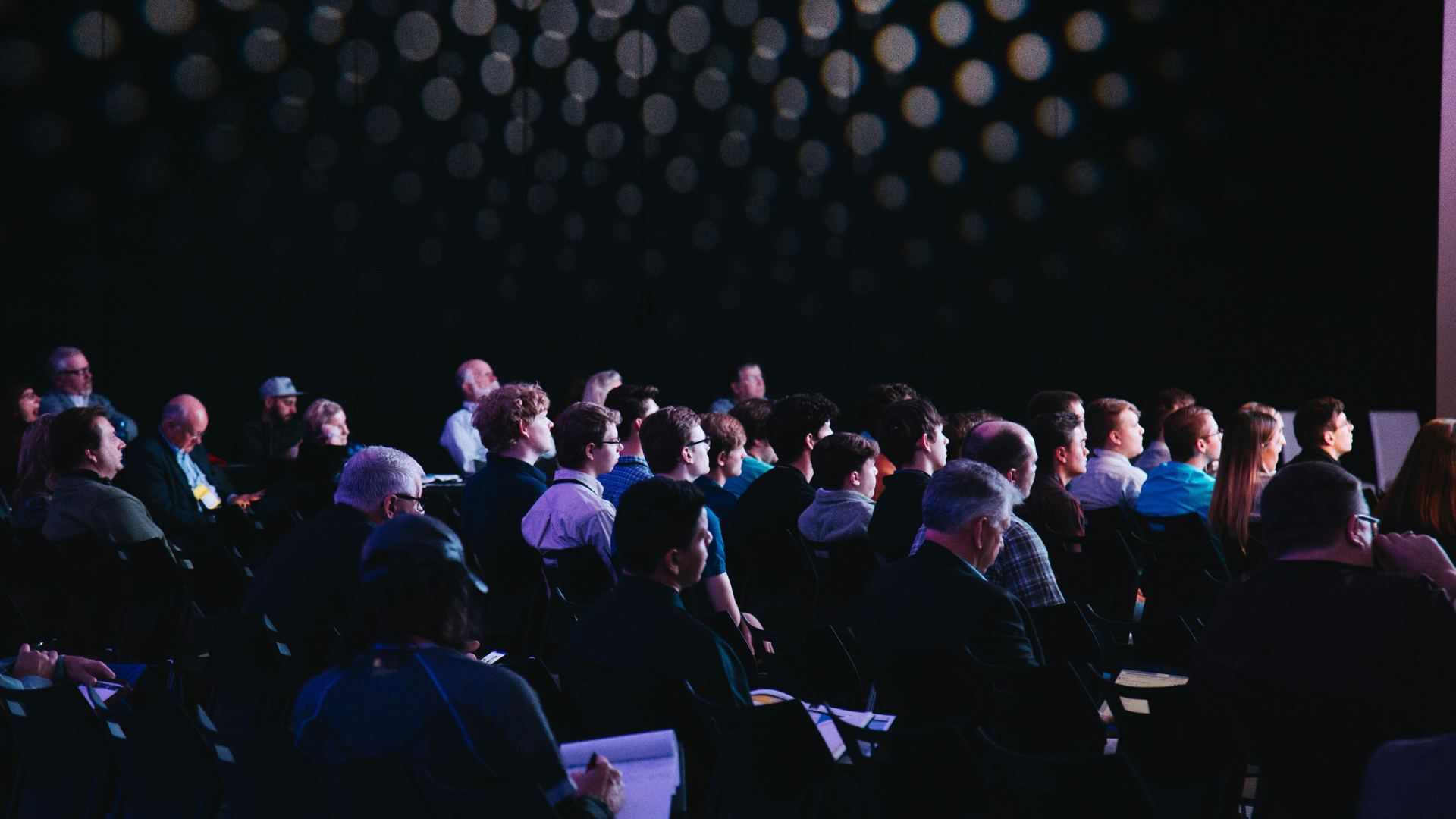 Image of people sat in rows at a conference.