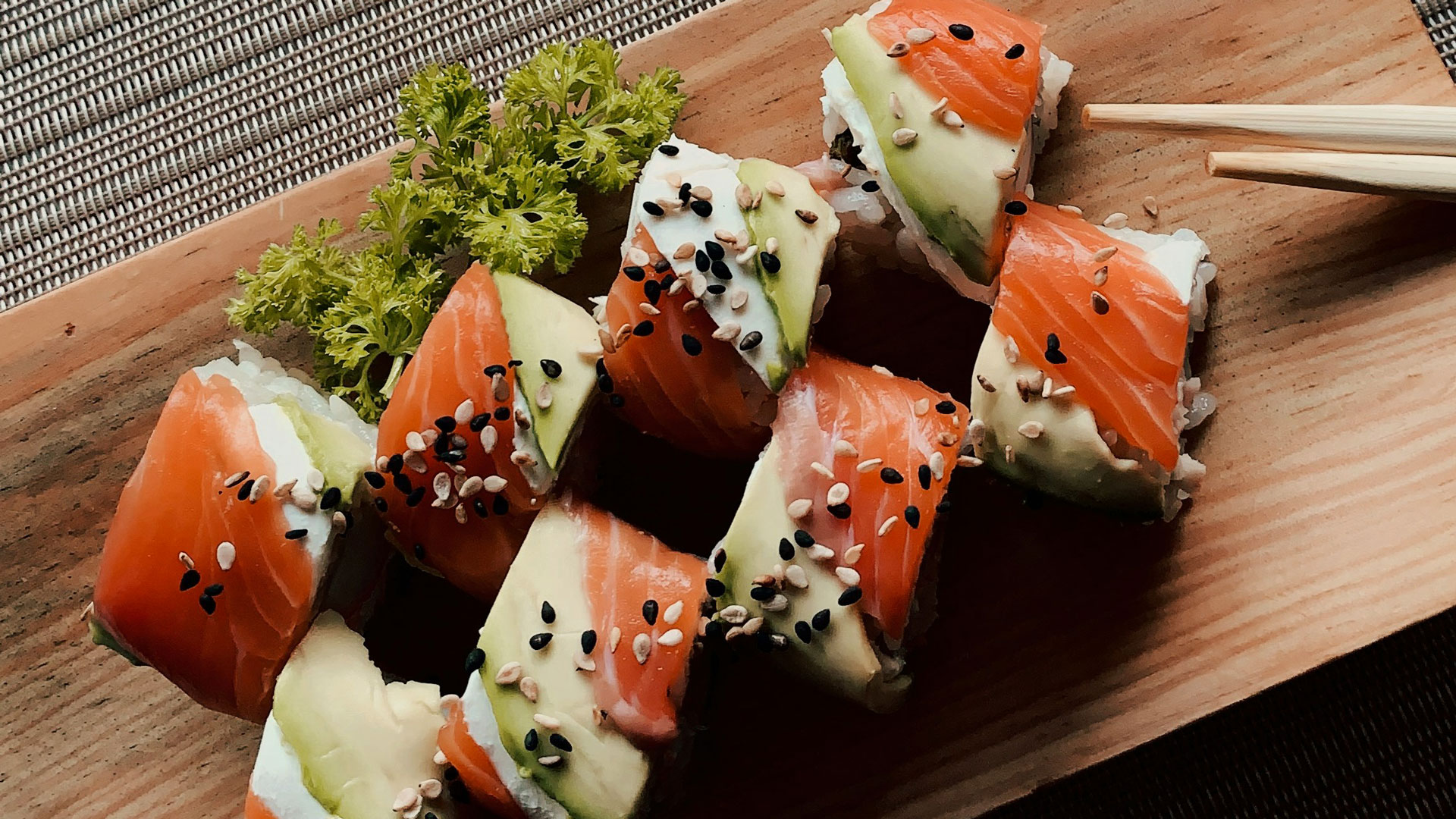 Photograph of sushi on a wooden board.