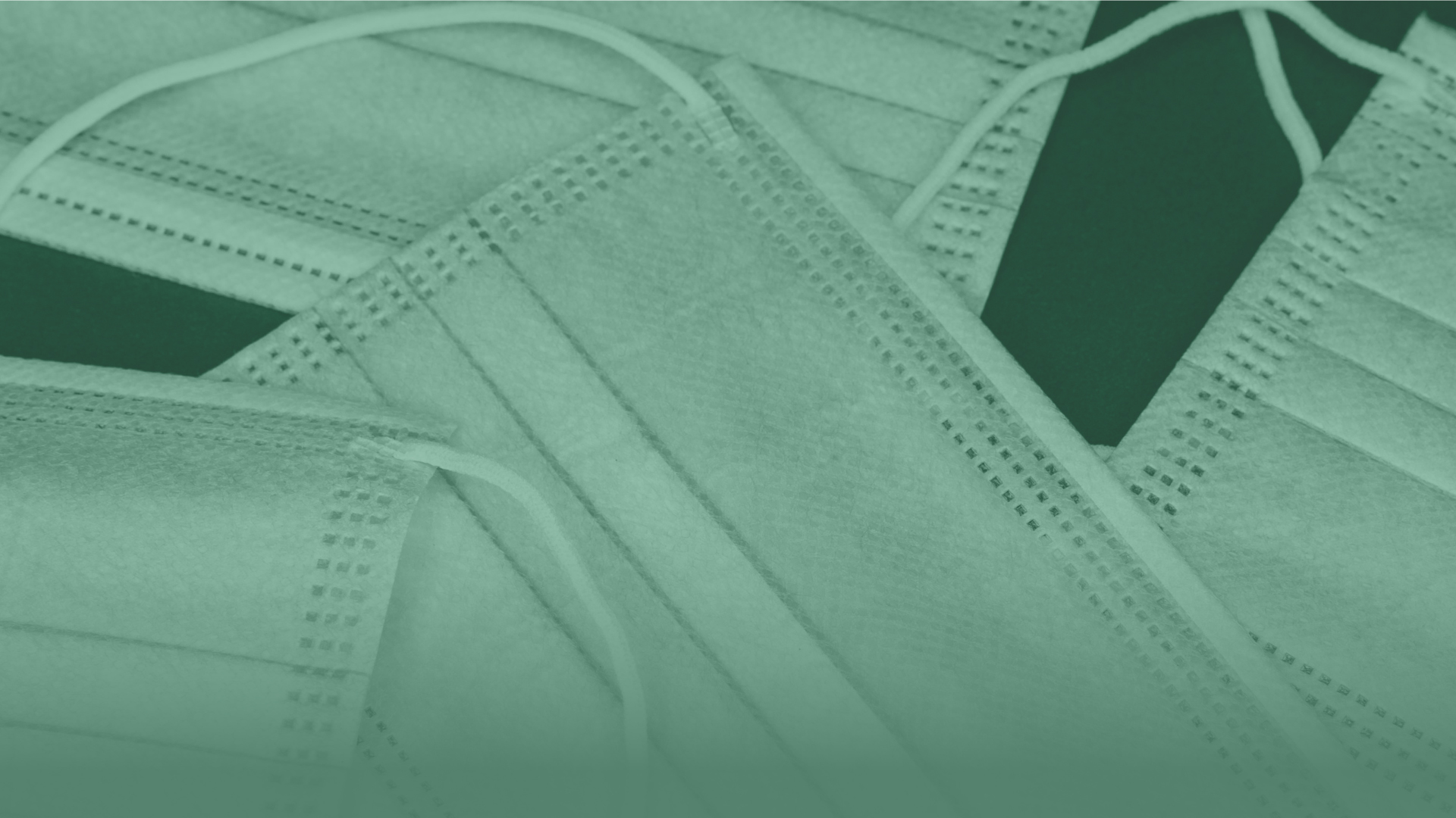 Abstract image of a close up of a pile of surgical face masks.