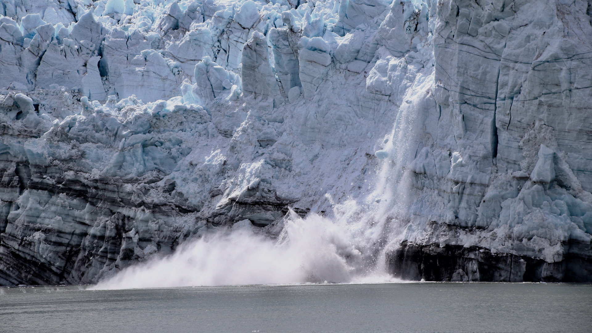 Ice breaking off a glacier and falling into the water.