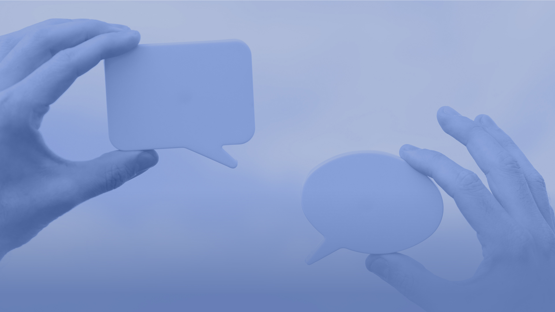 Abstract image of hands holding up two speak bubbles.