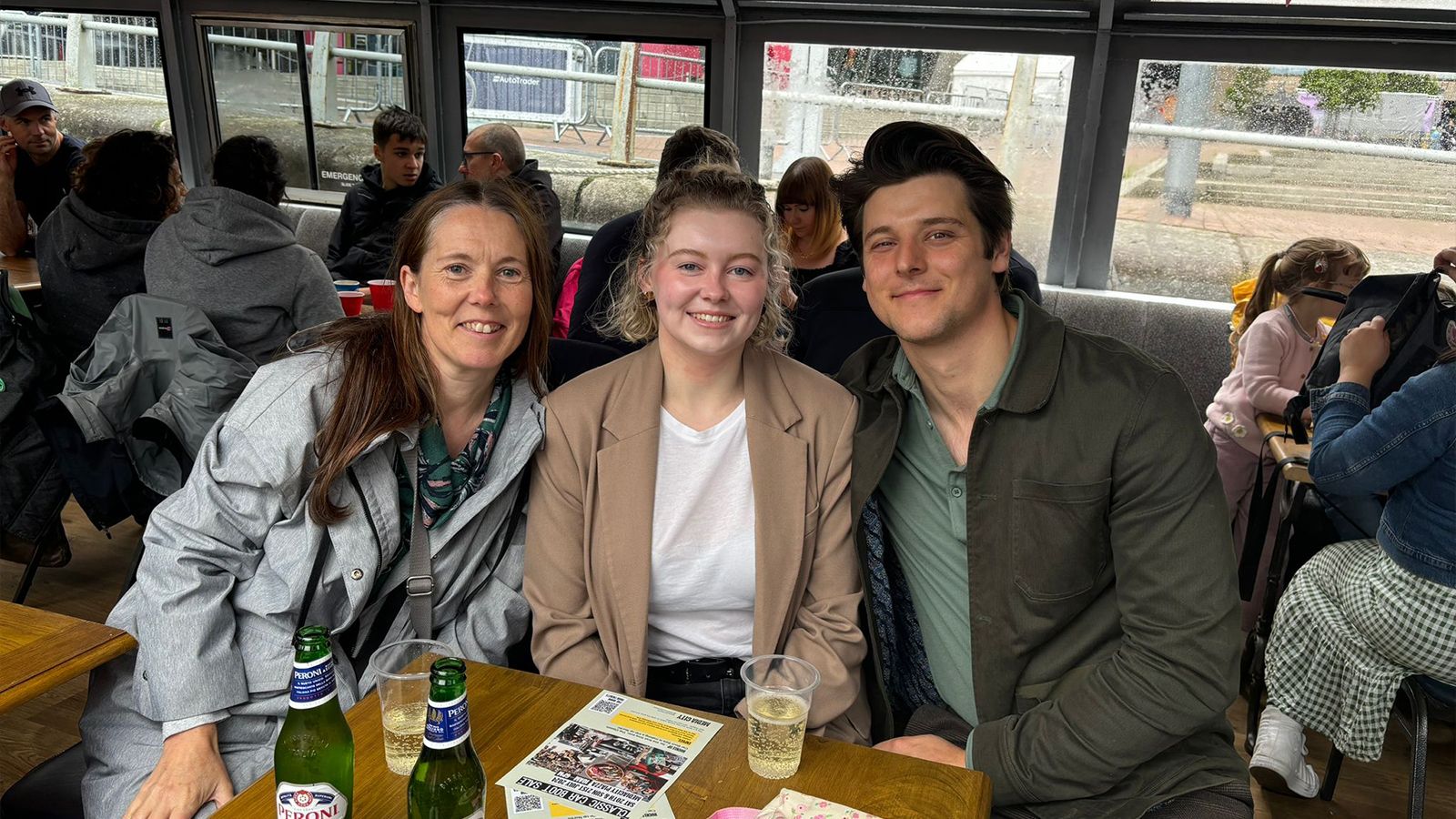 Kate and Ellie having drinks at a festival.
